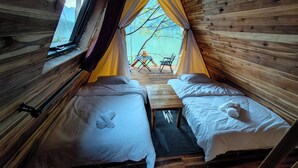 A cozy cabin with two beds, a small table, and a view of the outdoors. - Papaya Resort Nong Khiaw (Nong Khiaw)