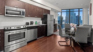 A modern kitchen with stainless steel appliances, a dining area with a view of the city, and a large window. - GLOBALSTAY Magnificent 1 Bedroom High Floor View (Toronto/Canada)