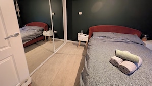A bedroom with a bed, a bedside table, a nightstand, a mirror, and a door. - Petfriendly 1bedapt - 5 Min From Beach Aberdeen (Aberdeen)
