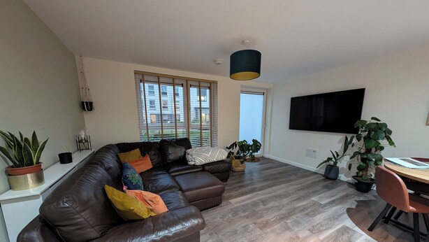 A modern living room with a leather sofa, a dining table, and potted plants. - Petfriendly 1bedapt - 5 Min From Beach Aberdeen (Aberdeen)