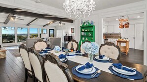 A dining room with a large table set for six, a chandelier, and a green cabinet with decorative items. - Hot Tub + Games + Mini Golf | Open Labor Day! (Canyon Lake)