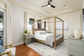 A bedroom with a four-poster bed, a nightstand, a dresser, and a ceiling fan. - Lake Views, Fire Pit, BBQ & Patio | Pet-Friendly! (Canyon Lake)