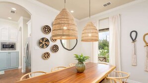 A dining area with a wooden table, wicker chairs, and pendant lights. - Lake Views, Fire Pit, BBQ & Patio | Pet-Friendly! (Canyon Lake)