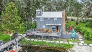 A waterfront property with a dock, a covered deck with seating, and a kayak. - cozy lakeside retreat (Silver springs)