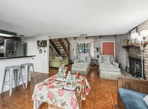 Un vaste espace de vie comprenant une salle à manger, une cuisine et un escalier menant à un niveau supérieur.