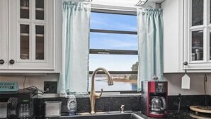 A kitchen with a sink, a coffee maker, and a microwave. - cozy lakeside retreat (Silver springs)