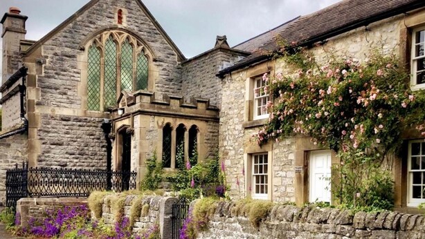 A stone building with a large arched window and a smaller window with a white door. - Peak District - 2 Beds - Sleeps 4 - Pet Friendly (Chesterfield)