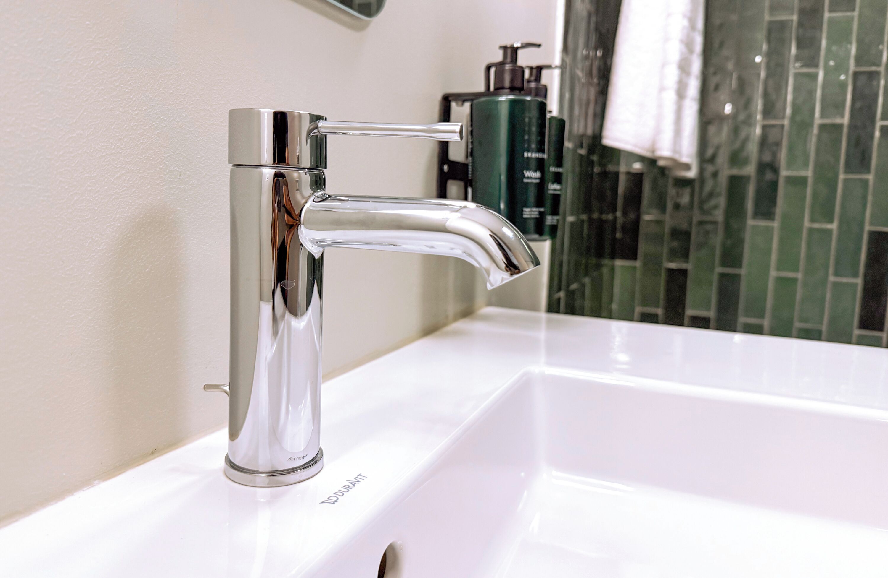 A modern bathroom with a chrome faucet and a white sink.