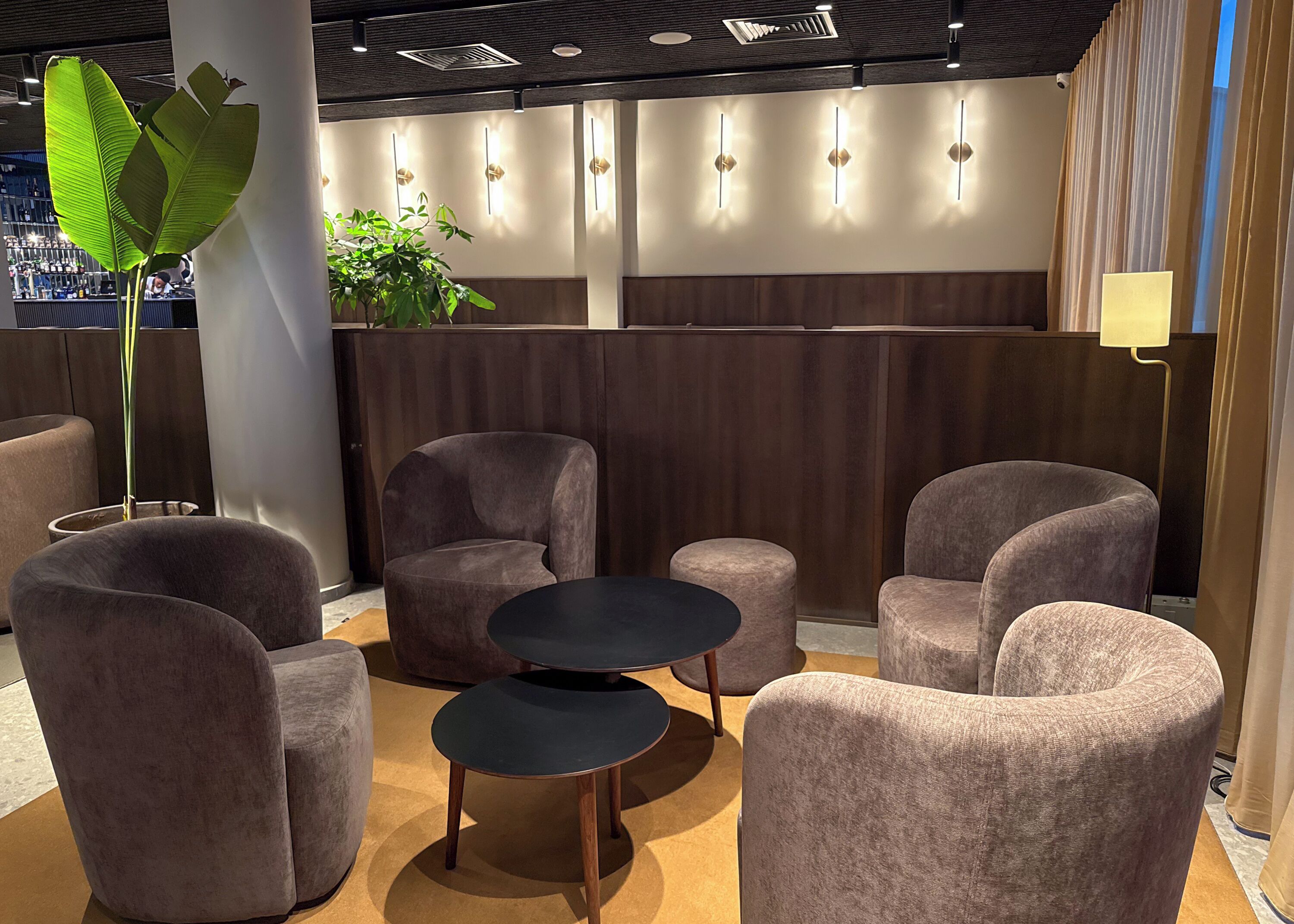 A modern lounge area with plush seating, a central round table, and ambient lighting.