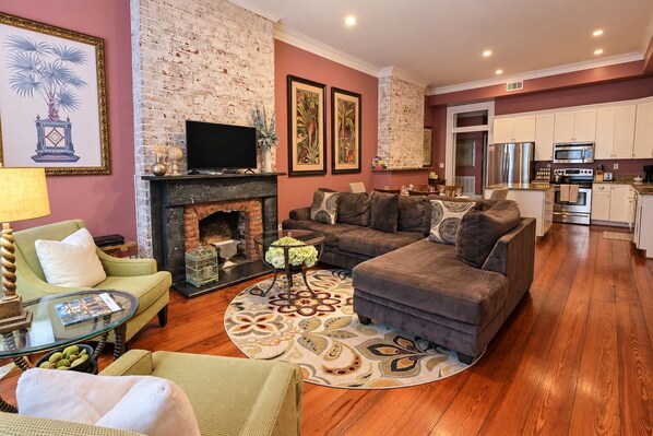 A living room with a fireplace, sofa, and television. - No Car Needed+King Bed+Balcony - Abercorn and York (Savannah)