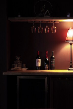 A bar area with three wine bottles, glasses, and a lamp. - Jacuzzi Tub! Walk to River Street & King Bed (Savannah)