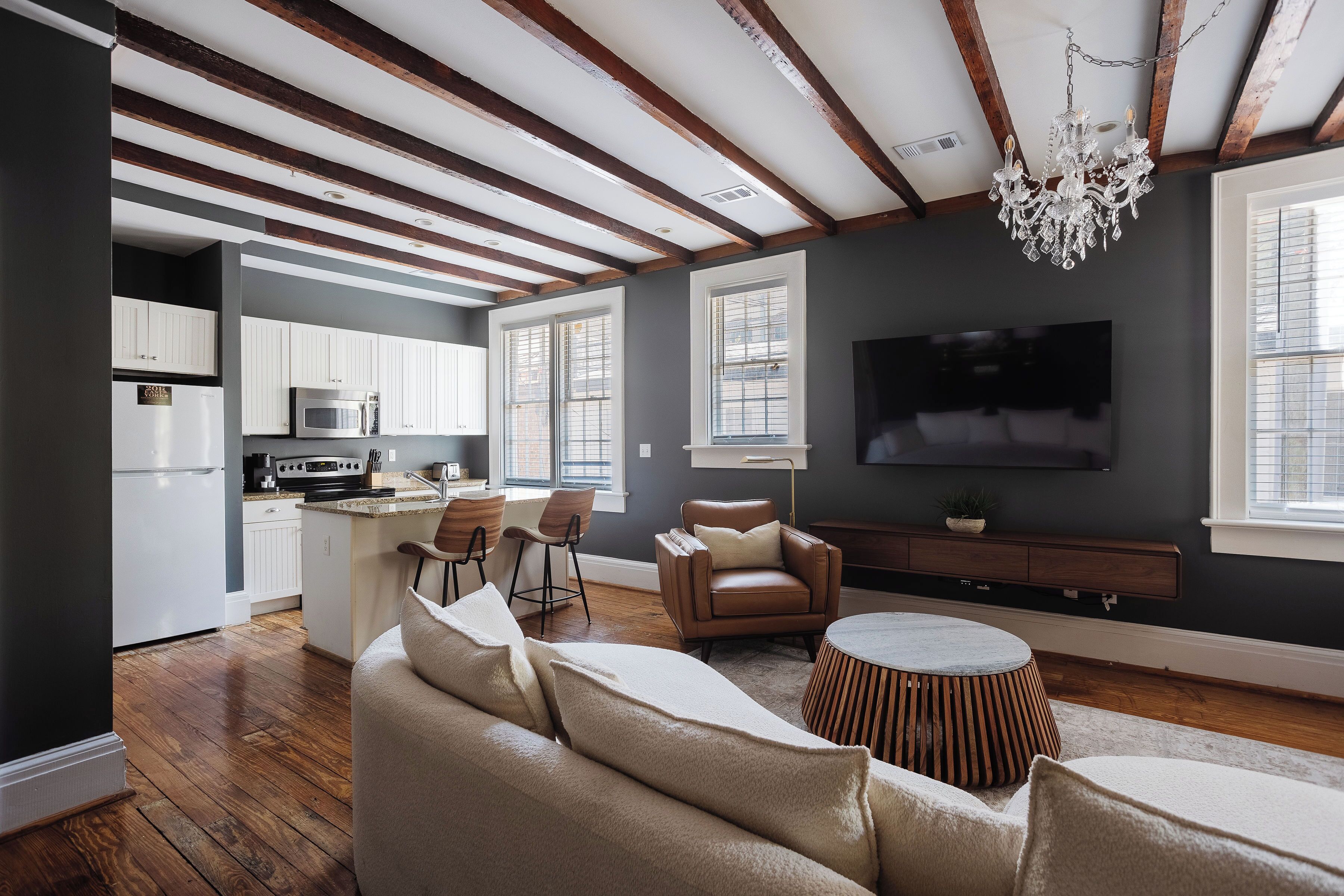 Una sala de estar moderna con chimenea, televisión y comedor.