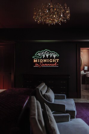 A dark room with a neon sign reading 'MIDNIGHT in Savannah' above a fireplace. - Jacuzzi Tub! Walk to River Street & King Bed (Savannah)