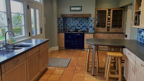 A kitchen with wooden cabinets, a blue stove, and a tiled backsplash.
