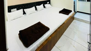 Habitación de hotel moderna con una cama grande, ventilador de techo y vistas al exterior.