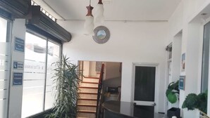 A hotel lobby with a reception desk, a staircase, and potted plants. - Hotel Paraiso Real (Cumbal)