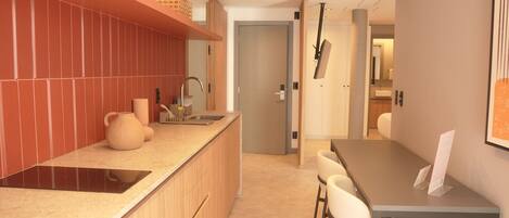 A modern kitchen with a wooden countertop, a built-in sink, and a dining area with a table and chairs.
