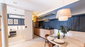 Una cucina moderna con zona pranzo, caratterizzata da un tavolo in marmo, sedie in legno e una lampada a sospensione.