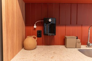 A modern kitchen with a coffee machine, a vase, and a trash bin. - Xtay Oslo Florianópolis (Florianópolis)