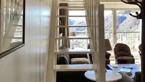 Een trap met witte leuningen die leidt naar een balkon met uitzicht op een berg.