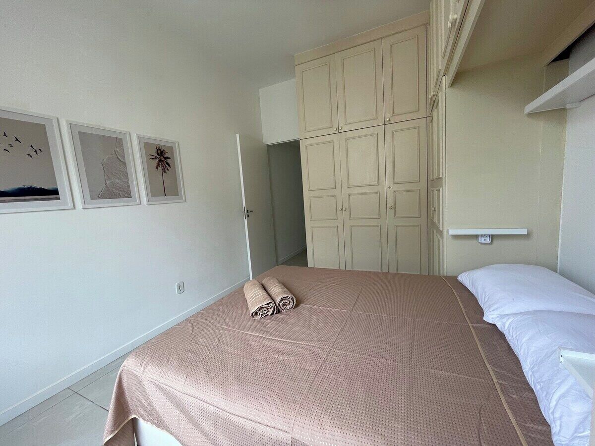 A bedroom with a bed, a wardrobe, and wall art.