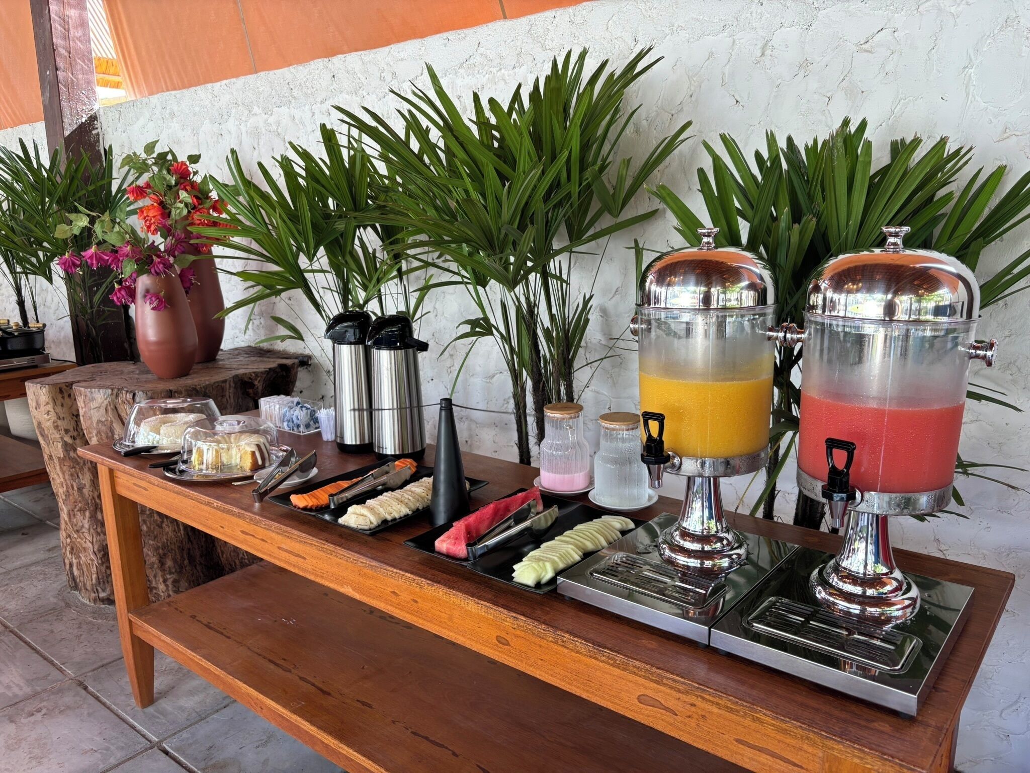 Montaje de bufé con diferentes alimentos y dispensadores de bebidas.