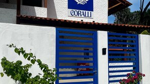 Um edifício com fachada branca e uma placa azul com a inscrição 