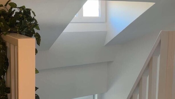 A staircase leading to a loft with a skylight and a small window. - Rudbecksgatan  (Eskilstuna)