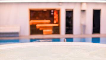 Una piscina con un fondo desenfocado de un edificio de diseño moderno y amplias ventanas.