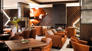 Un interior moderno con asientos de cuero, chimenea y un diseño geométrico en la pared.