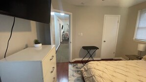 A bedroom with a bed, a dresser, a small table, a lamp, and a ceiling fan. - Chic & Spacious 3-Bedroom Retreat in the Heart of Clarksville (Clarksville)
