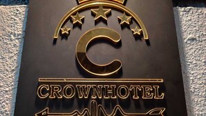 Metallinen kyltti, jossa on kruunu ja tähtiä, ja jossa lukee: ”Crown Hotel”.