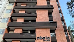 A modern building with a sign reading "akela PARK". - Akela Park (Medellín)