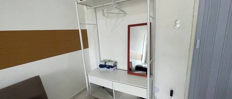A bunk bed with a mirror, a small shelf, and a hanging rack.