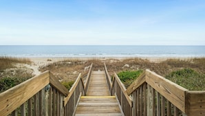 A wooden boardwalk leading to a beach with the ocean in the background. - Beach Retreat: Oceanfront Upper Level Corner Unit Close to Community Pool (Oak Island)