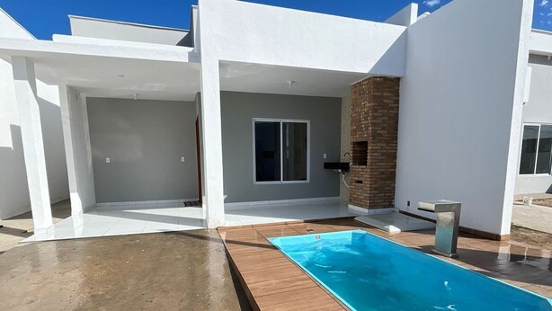 A modern house with a swimming pool, a covered patio, and a brick wall. - Casa Corais Beach Francês (Marechal Deodoro)