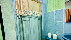 A bathroom with a shower curtain, a toilet, and a sink. - Hotel Emiss Panajachel  (Panajachel)