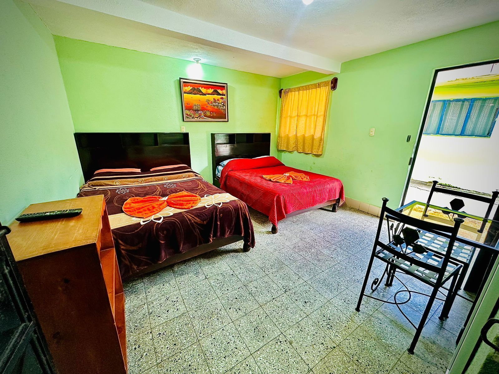 Una habitación con dos camas, un escritorio y una silla.