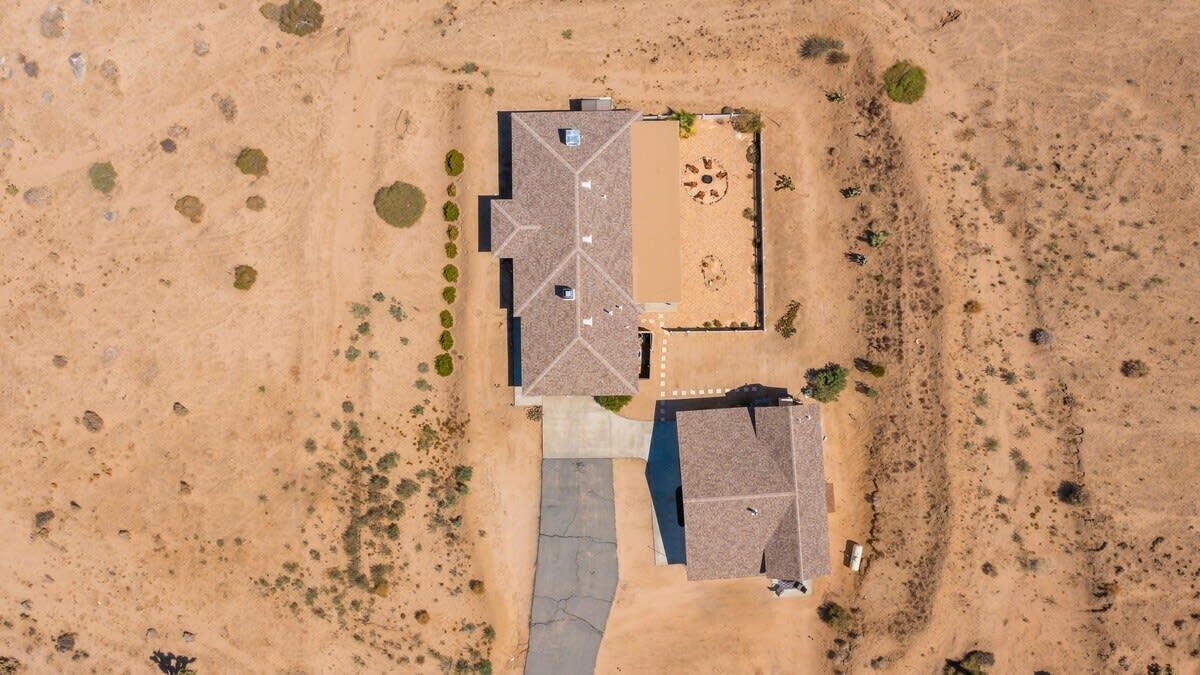 An aerial view of a building with a central courtyard, a swimming pool, and a small adjacent structure.
