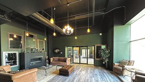 A spacious living room with a fireplace, leather sofas, and a chandelier. - Luxury Studio Apartment Near McCormick Place & Soldier Field (Chicago)