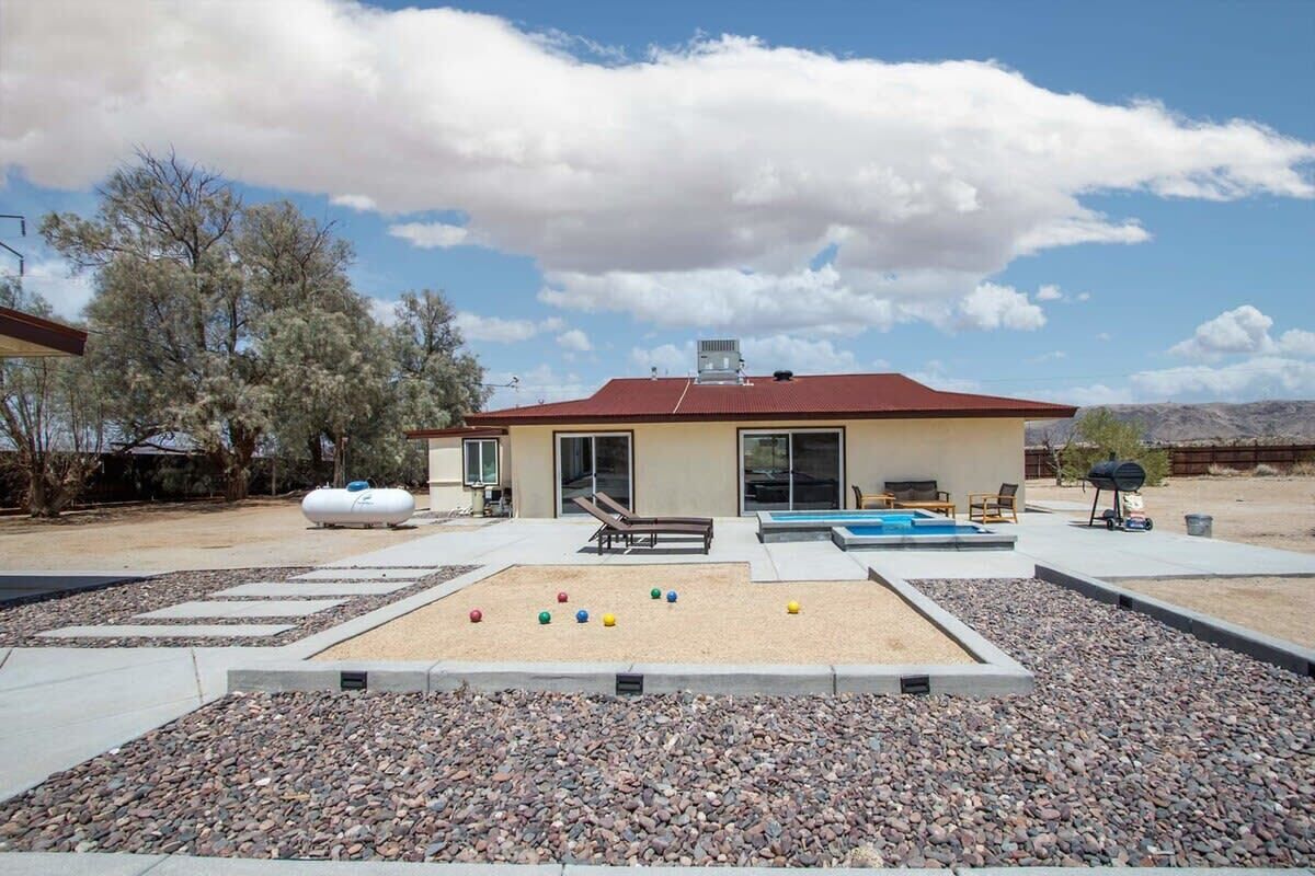 Uma casa moderna com piscina, área de estar ao ar livre e um alpendre.