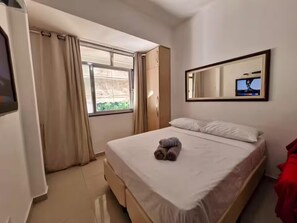 A hotel room with a bed, a window with curtains, a mirror, and a television. - 360 Leme Beach Anchieta By SUHCasa (Rio de Janeiro)