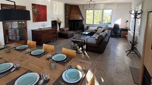 A spacious living area with a fireplace, a dining table set for four, and a cozy seating area with a sofa and armchairs. - Rental Villa, 200m², 6 bedrooms, sleeps up to 12, swimming pool, Montauroux (Montauroux)