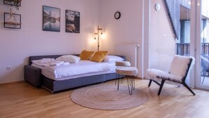 Une chambre à coucher avec un lit, une chaise, un tapis rond et des œuvres d’art accrochées au mur.