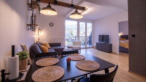 Un salon moderne avec une table à manger, des canapés et un téléviseur.
