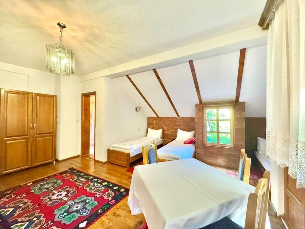 A bedroom with a wooden ceiling, a bed, a window, and a door.