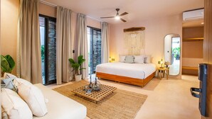 A bedroom with a bed, a ceiling fan, a large mirror, a bedside table with a lamp, and a view of the outdoors through the window. - Marakame San Pancho (San Francisco)