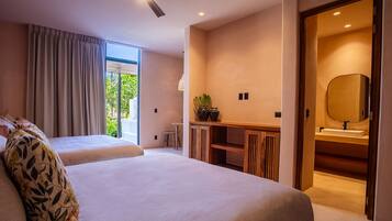 A modern hotel room with two beds, a desk with a mirror, and a view of greenery outside.
