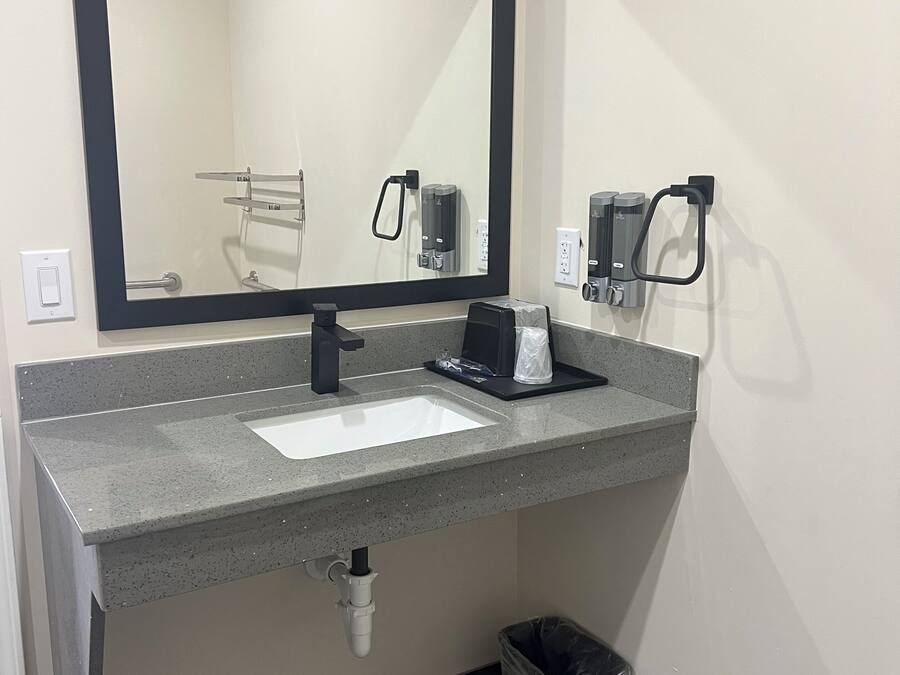 Un bany modern amb un mirall gran, un lavabo i un gresol.