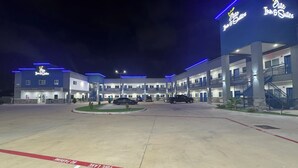 Un hôtel à plusieurs étages, reconnaissable à son enseigne bien visible indiquant « Elite Inn & Suites ».